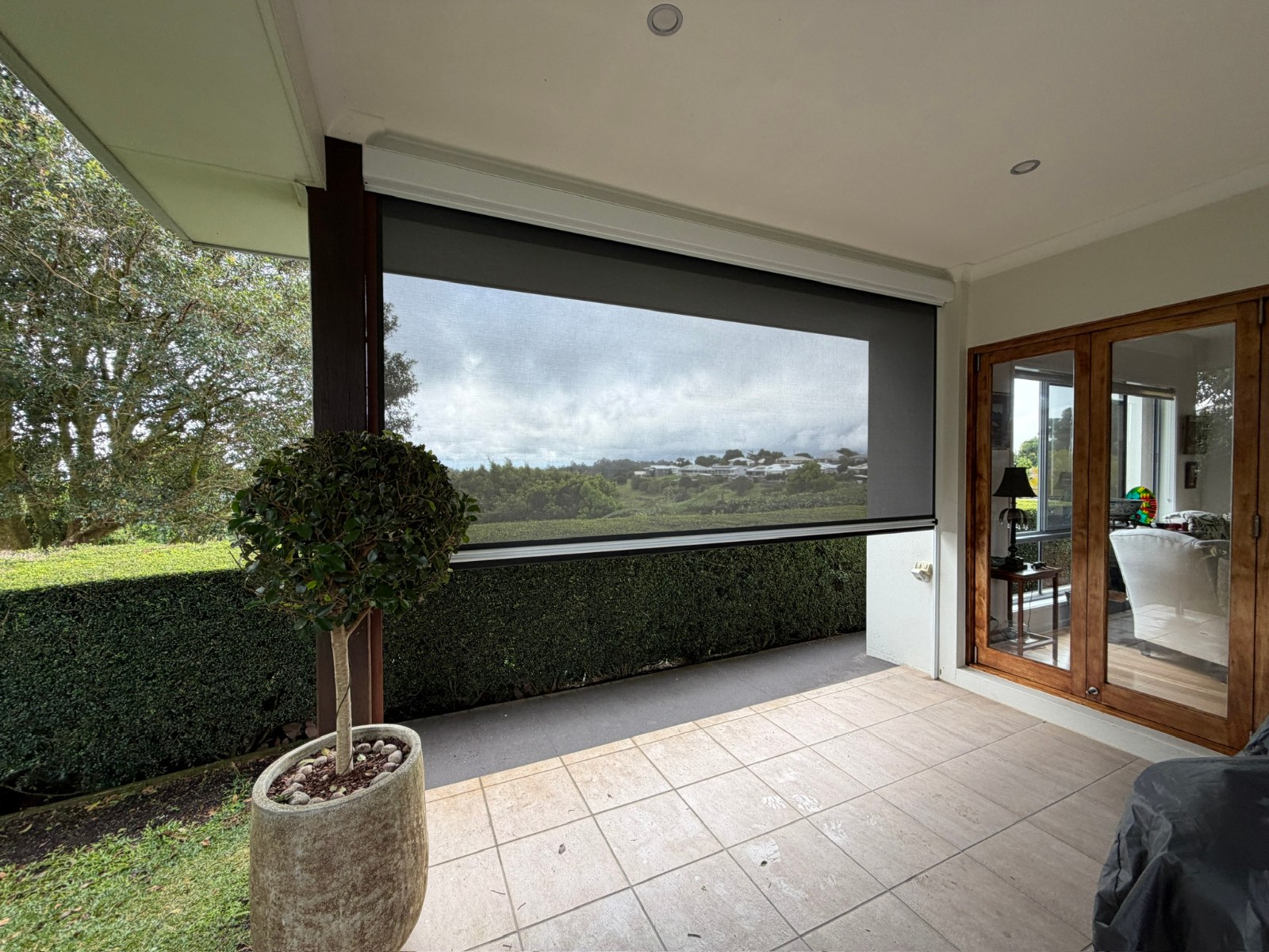 Zipscreen outdoor blind lowered across a covered patio with hinterland valley views in Maleny, Sunshine Coast